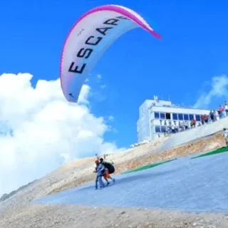 Взлетите с высоты 2365 м на гору Тахталы вместе с опытными пилотами, насладитесь потрясающими видами и приземлитесь на пляже Текирова. Включает канатную дорогу и трансфер в отель.